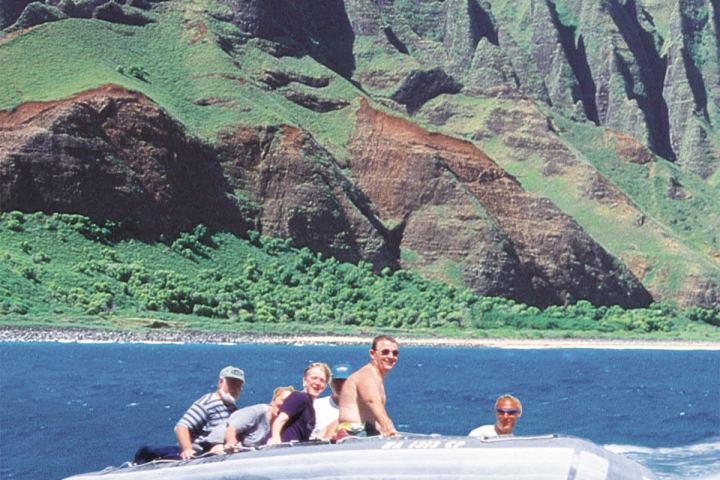 a group of people riding on the back of a boat in the water