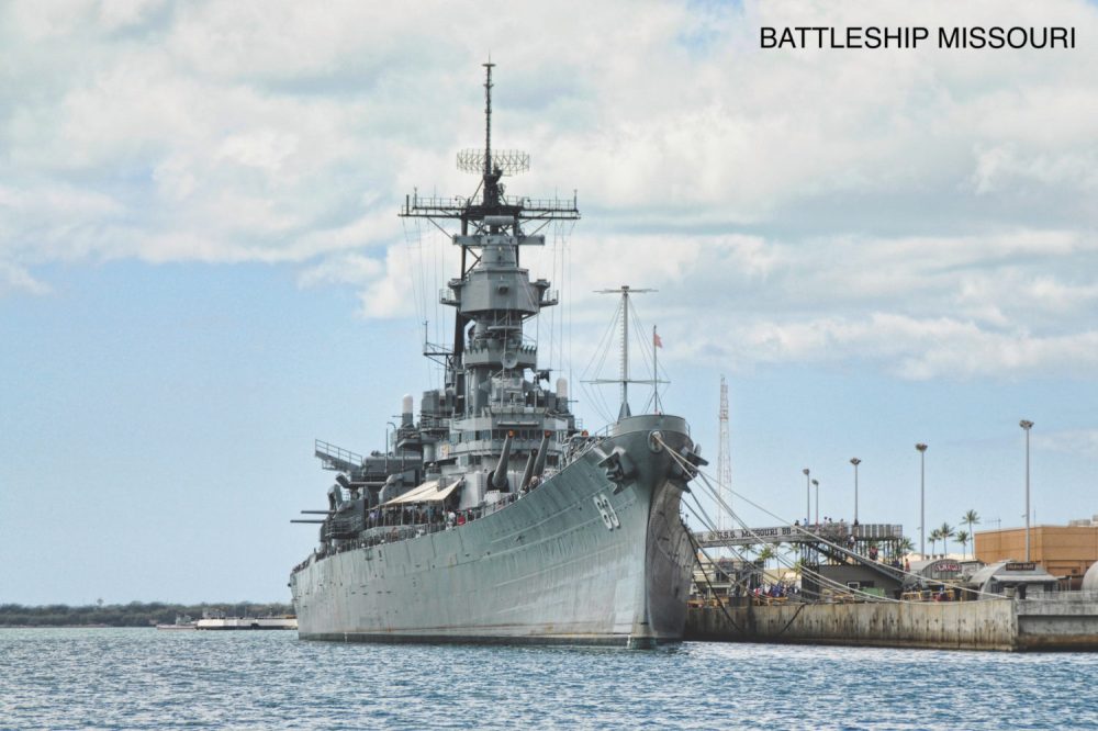 a large ship in a body of water with USS Missouri (BB-63) in the background