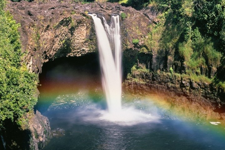 a large waterfall in a forest with Rainbow Falls in the background